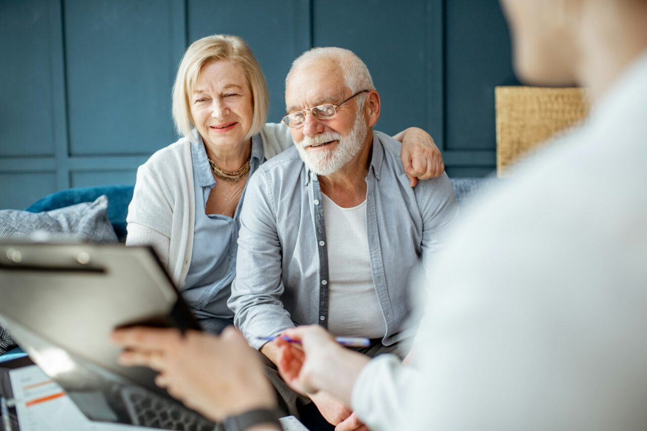senior-couple-with-consultant-at-the-office-e1715621317278